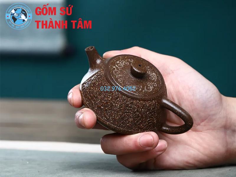 Nghệ nhân chạm khắc các hoa văn và họa tiết lên bề mặt ấm